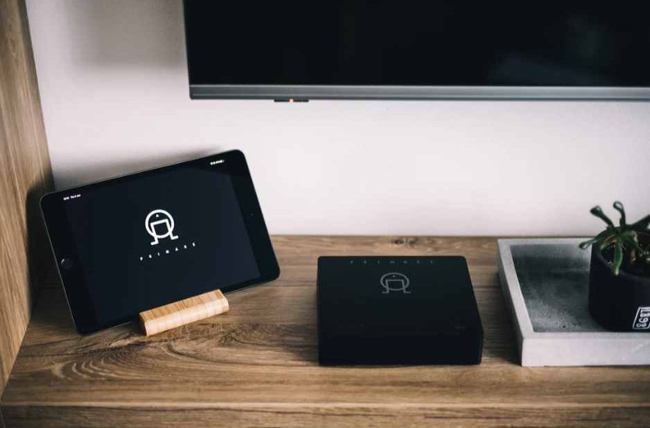 Primare NP5 Prisma MK2 Network Music Player Streamer - Lifestyle photo sitting on table below tv next to a tablet