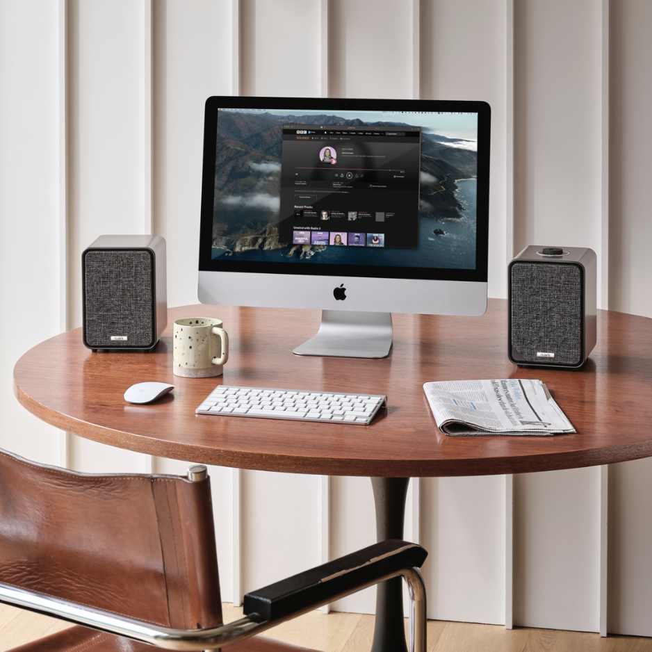 Ruark Audio MR1 MK3 Desktop Speaker System Next to Mac Computer with Keyboard and Newspaper