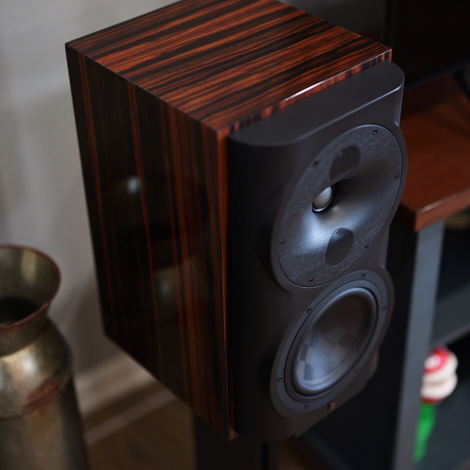 Perlisten S4b bookshelf speaker in High Gloss Ebony finish, diagonal view from above showing the rich striped ebony wood veneer