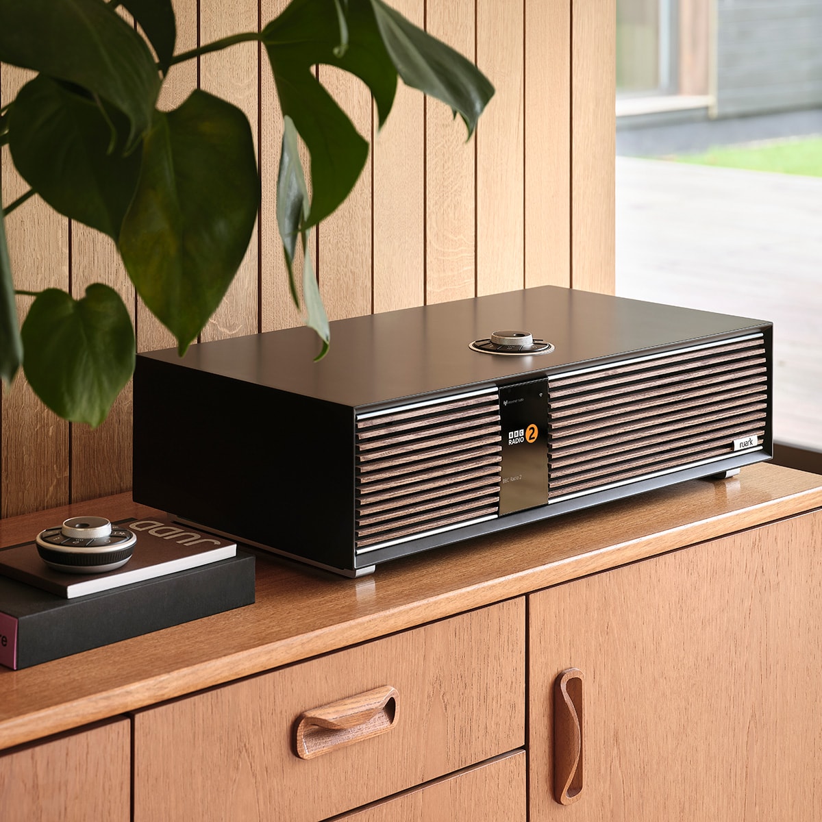 Ruark Audio R410 All-In-One Music System in Satin Charcoal, lifestyle on light wood credenza with plant