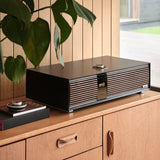 Ruark Audio R410 All-In-One Music System in Satin Charcoal, lifestyle on light wood credenza with plant