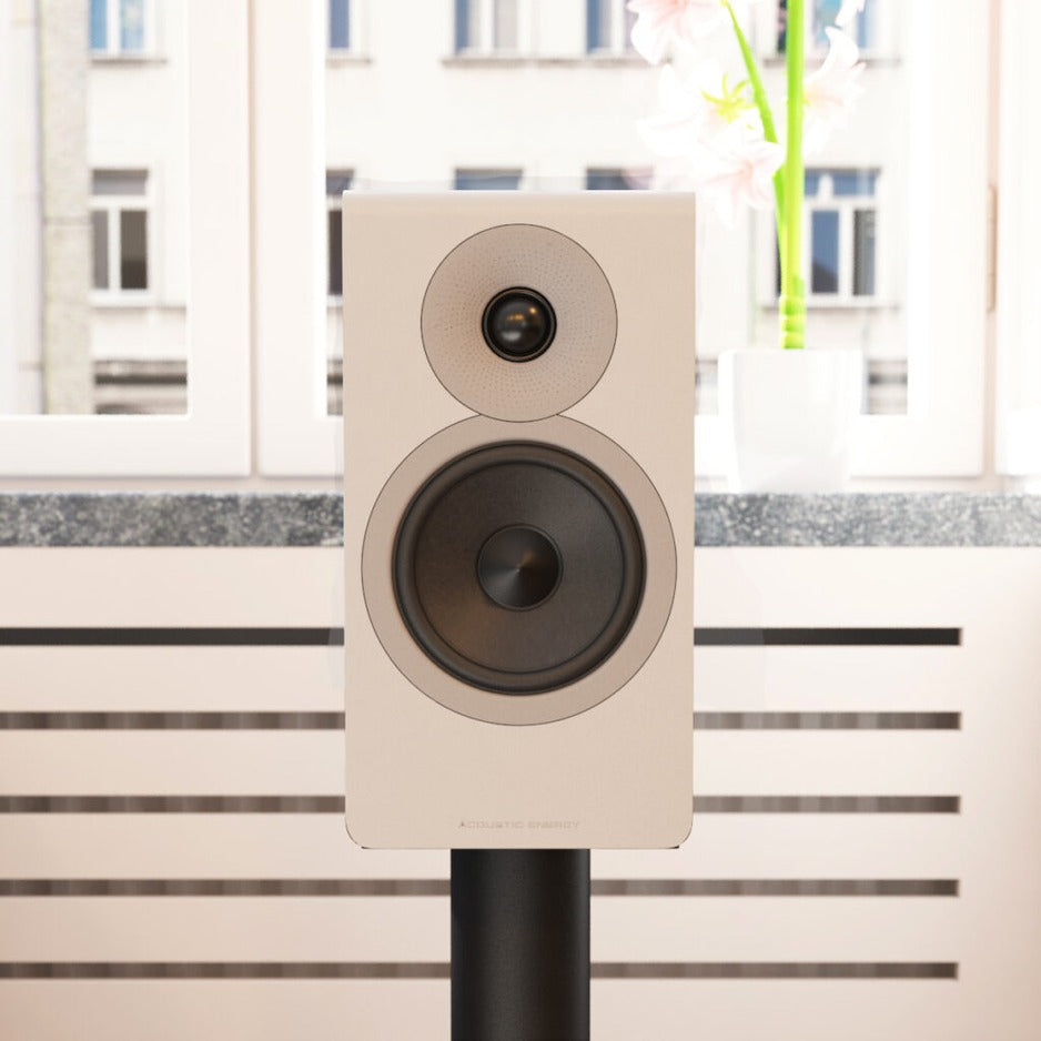 Acoustic Energy AE300² in silk-touch matte white on a stand in a modern living room, grille removed to show the drivers