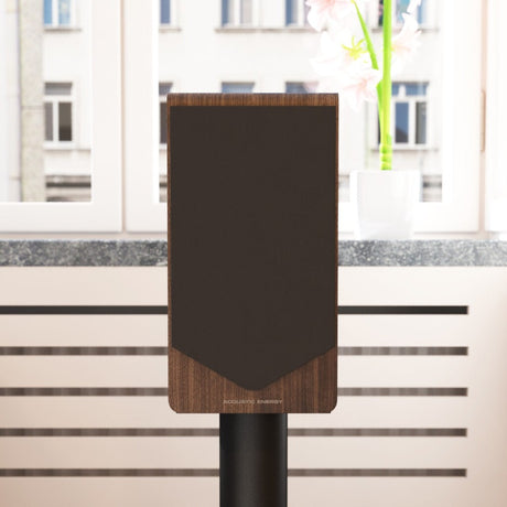 Acoustic Energy AE300² in walnut veneer with grille on, on a stand in a modern living room