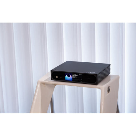 Matrix Audio mini-i Pro 4 on modern stand with screen displaying album art against white curtain backdrop