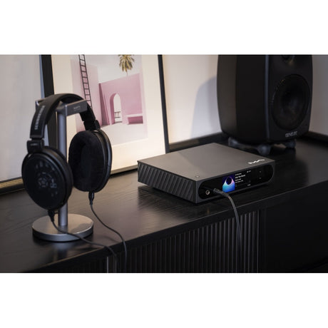 Matrix Audio mini-i Pro 4 in desktop setup with headphones on stand and Genelec speaker showing headphone output in use