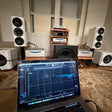 Two-channel system calibration in a listening room: REW measurement on Mike's laptop in front of the speakers and three subwoofers